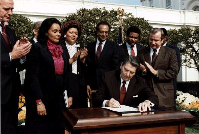  Coretta Scott King looks on as President Reagan signs the bill making Dr. King’s birthday a national holiday, 1983. (Wikimedia Commons/White House Photo)
