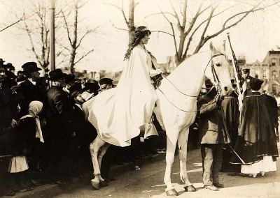 Inez Milholland wearing white cape, seated on white horse at the National American Woman Suffrage Association parade, March 3, 1913, Washington, D.C. (Library of Congress)
